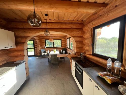 una cucina e una sala da pranzo di una baita di tronchi di Oasis Chalet a Lisnău