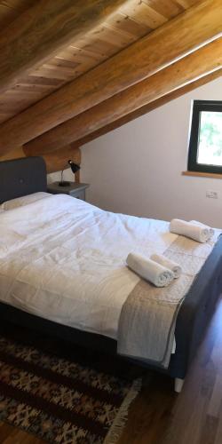 a bedroom with a bed with two towels on it at Oasis Chalet in Lisnău
