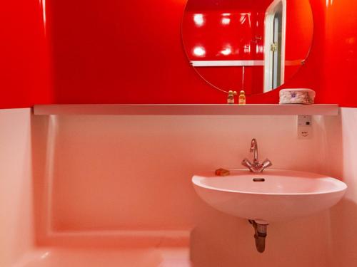 a red bathroom with a sink and a mirror at Appartement 6 personnes au centre, balcon, parking, Wifi - FR-1-346-470 in Arc 1800