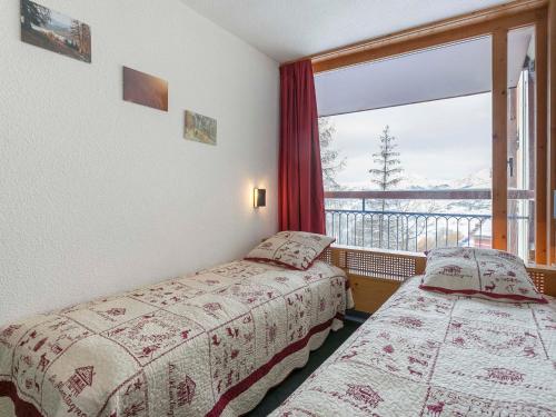 two beds in a room with a large window at Appartement 6 personnes au centre, balcon, parking, Wifi - FR-1-346-470 in Arc 1800