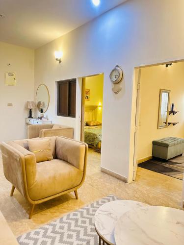 カラチにある2-BR Apartment-3 min airportのソファと壁掛け時計のあるリビングルーム