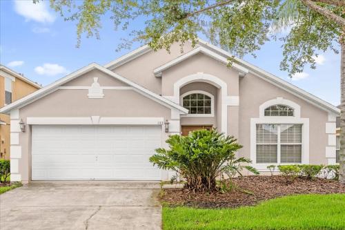 een huis met een witte garage bij Summer Getaway - 5-Bedroom Home with Private Pool! in Kissimmee
