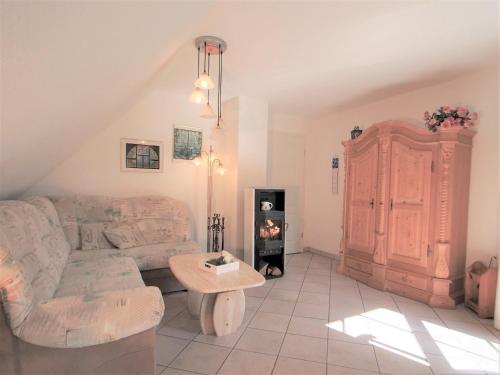 Una sala de estar con un sofá y una chimenea. en Birkmaase 14 - Komfort FeWo im 4-Sterne-Ferienhaus Anselm DG, en Zingst