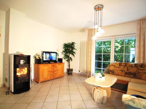 Una sala de estar con un sofá y una chimenea. en Birkmaase 16 - Komfort FeWo im 4-Sterne-Ferienhaus Manuela EG, en Zingst