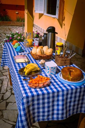 a blue and white checkered table with food on it at Pousada Sol do Araçá in São Sebastião