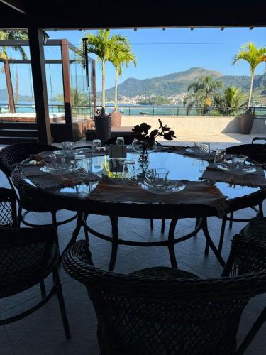 un tavolo con piatti e bicchieri su un patio di Sintonia com Mar ad Angra dos Reis