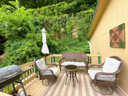 una terraza con sillas, una mesa y una sombrilla en Bluffside Chalet Suite, en McGregor