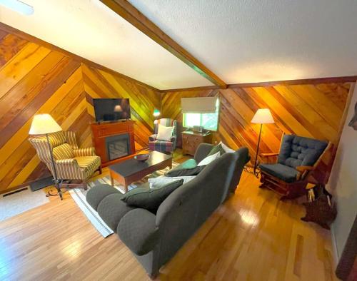 Una sala de estar con un sofá y sillas y un televisor. en Bluffside Chalet Suite, en McGregor