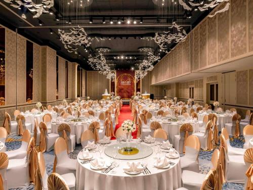 a large banquet hall with white tables and chairs at Sofitel Saigon Plaza in Ho Chi Minh City