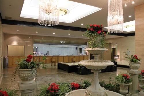 a lobby with a large lobby with flowers in a building at Hotel Nagoya Garden Palace in Nagoya