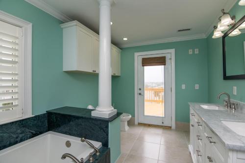 een badkamer met blauwe muren en een ligbad bij Hannah's Choice in Edisto Island