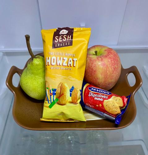 a tray with apples and a bag of crisps and snacks at Ella Cottage - Relaxing romantic escape-Southern Highlands 