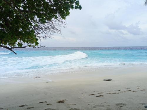 a beach with footprints in the sand and the ocean at Save Sweet Home in Fuvahmulah