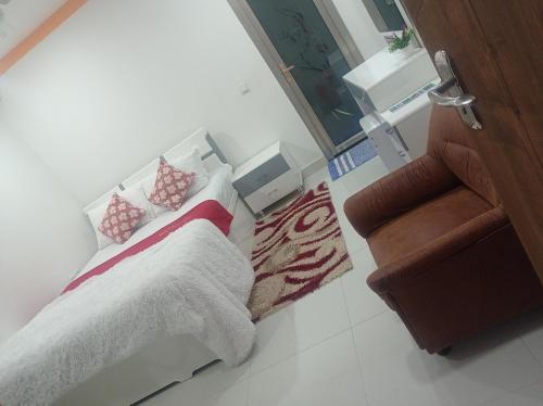 a small bedroom with a bed and a staircase at Save Sweet Home in Fuvahmulah