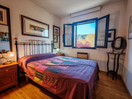 un dormitorio con una cama y una ventana en Confort excelente- Chimenea, sol y bien equipado - Falcó 10, en Pla de l'Ermita