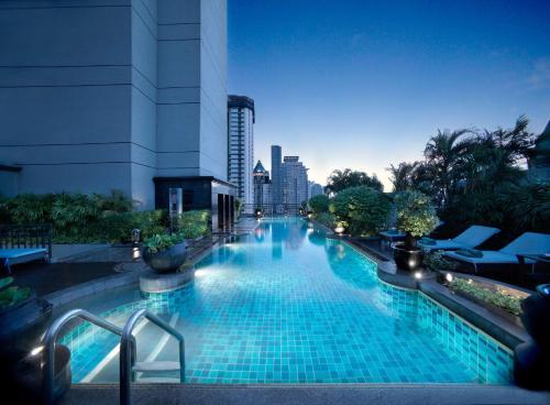 a large swimming pool with a city skyline in the background at Banyan Tree Bangkok in Bangkok