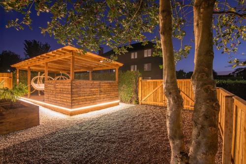 a wooden gazebo in a yard with a tree at Private Hot Tub - Garden - Free Parking -2bdrm - 5ppl - Zen & Bubbles in Edinburgh