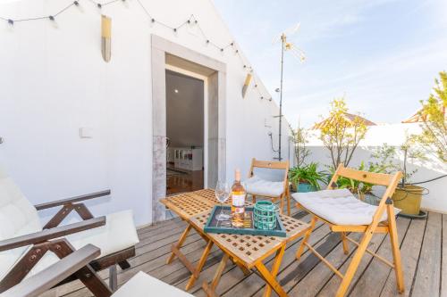 a patio with a table and chairs on a balcony at Casa Alecrim in Tavira