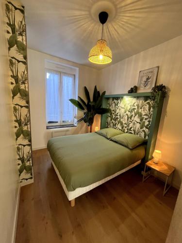 een slaapkamer met een groen bed en een lamp bij L'Oxygène -400m de la gare in Saint-Brieuc