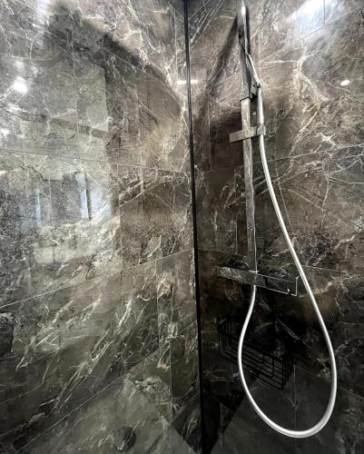 een douche met een slang in een stenen badkamer bij L'Oxygène -400m de la gare in Saint-Brieuc