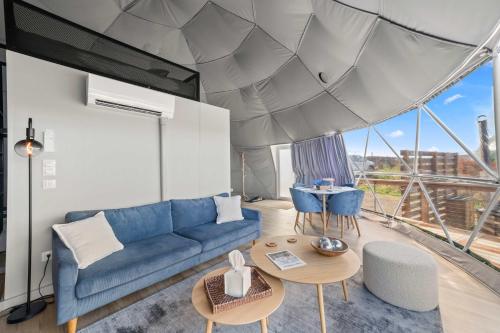 a living room with a blue couch and a table at Barrel Hot Tub at 'The Eagle Dome' in Franklin in Franklin