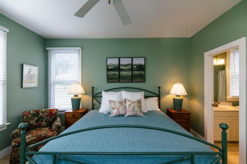 a green bedroom with a bed and a chair at Tequila Sunset in Edisto Island