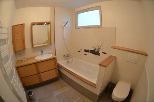 ein Badezimmer mit Badewanne, Waschbecken und Toilette in der Unterkunft Chambre de 15m2 à la campagne avec salle de bains in Vacqueville