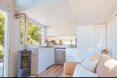 cocina con sofá y fogones en una habitación en Puka Mala Tiny House, en Ciudad del Cabo