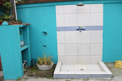 ein blau-weiß gefliestes Badezimmer mit einer Tür in der Unterkunft Vila Azular Ubatuba 50m da Praia, Casas Completas & Estacionamento in Ubatuba