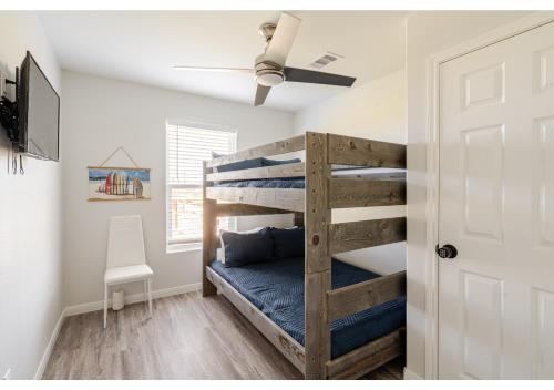 ein Schlafzimmer mit Etagenbett und Deckenventilator in der Unterkunft Blue Lagoon with Hot Tub and Golf Cart! in Bolivar Peninsula