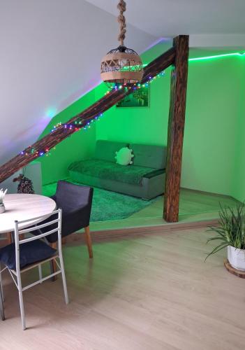 a green living room with a couch and a table at KissApartman in Kőszeg