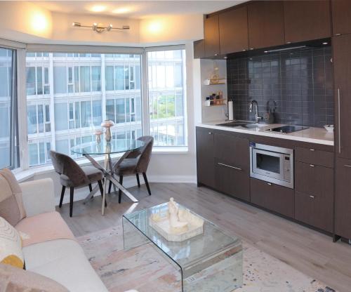 a kitchen and living room with a table and chairs at Cozy Studio in the heart of Yorkville in Toronto
