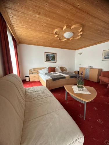 ein Schlafzimmer mit einem Bett, einer Couch und einem Tisch in der Unterkunft Grunen Baum - Vöran in Vöran