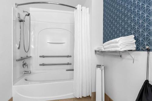 a bathroom with a tub and a shower curtain at Country Inn & Suites By Radisson, Charleston North, SC in Charleston