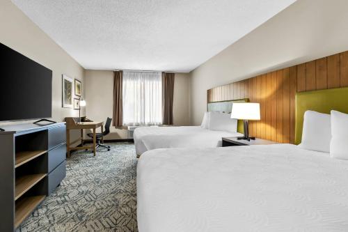 a hotel room with two beds and a desk at Country Inn & Suites By Radisson, Charleston North, SC in Charleston