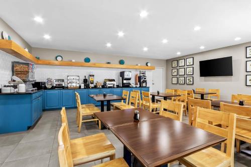 a restaurant with tables and chairs and a kitchen at Country Inn & Suites By Radisson, Charleston North, SC in Charleston