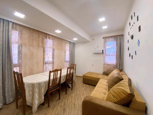 a living room with a couch and a table and a dining room at Green Garden Dilijan in Dilijan