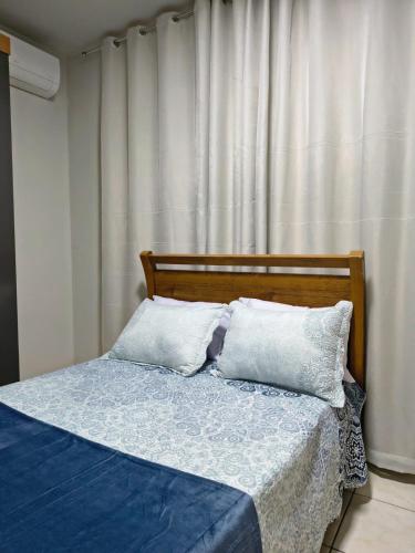 a bed with two pillows on it in a bedroom at Apartamento inteiro Iguaçu Ipatinga in Ipatinga