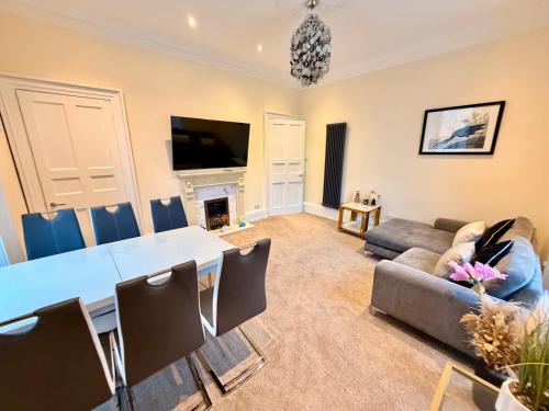 un salon avec une table et un canapé dans l'établissement Georgian Luxury Apartment - Fast Broadband WiFi - Parking Available, à Édimbourg