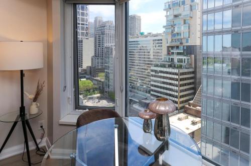 a glass table in a room with a large window at Cozy Studio in the heart of Yorkville in Toronto