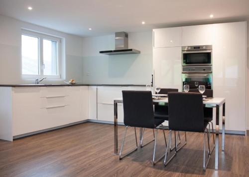 a kitchen with a table and chairs in a kitchen at Ferien Im Toggenburg in Ebnat