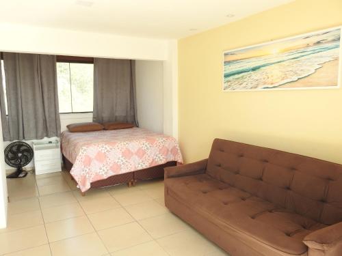 een woonkamer met een bank en een bed bij Cobertura Maison dos Colibris in Arraial do Cabo
