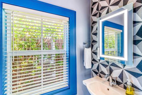 Un baño con una ventana azul y un lavabo. en Tropical Vibes, en Key West