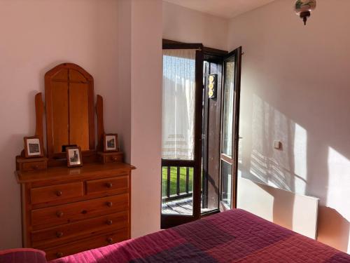 ein Schlafzimmer mit einem Bett, einer Kommode und einem Fenster in der Unterkunft Chimenea en invierno, piscina en verano - Herbasabina 3 in Pla de l'Ermita