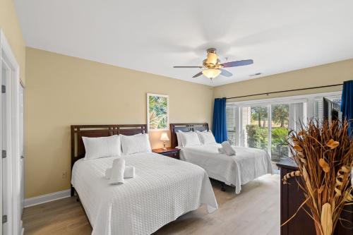 a bedroom with two beds and a ceiling fan at World Tour 2BR Golf View Pool & Patio in Myrtle Beach