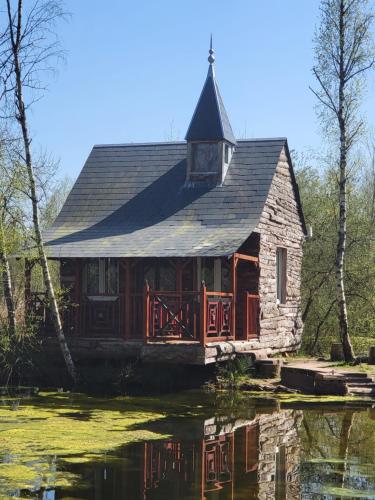 a house sitting on top of a body of water at Cabane atypique sur une Île in Sury-aux-Bois