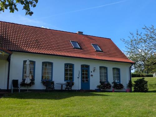 een wit huis met een rood dak bij Landhaus Freche Socke in Buchhorst