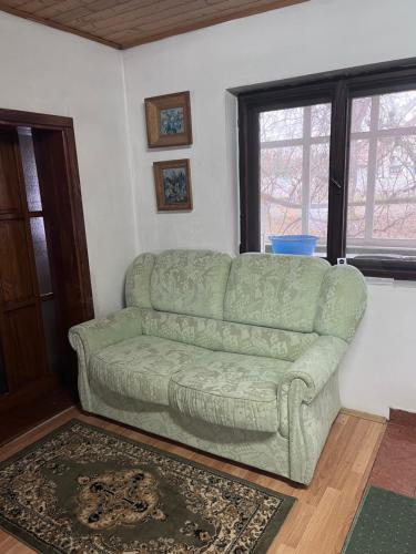 a green couch sitting in a living room at Kuća za odmor Sremac in Apatin