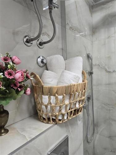 a basket of towels on a wall in a bathroom at Apartman Karamelica in Užice