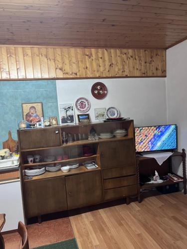 a kitchen with wooden cabinets with plates and dishes at Kuća za odmor Sremac in Apatin